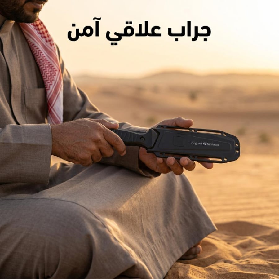 سكين صيد مطواة 25 سم بيد رجل في الصحراء ت ظهر تصميمها الأسود العملي