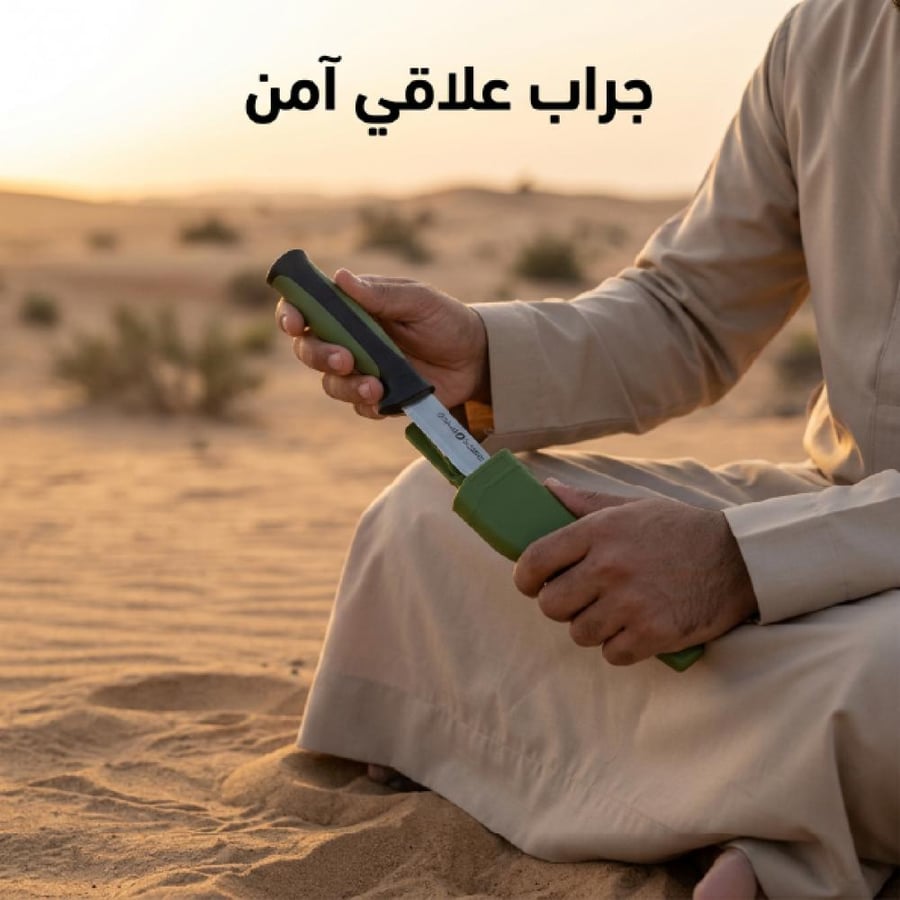 شخص يجلس في الصحراء يحمل سكين صيد بنصل فولاذي قصير ومقبض آمن وغمد