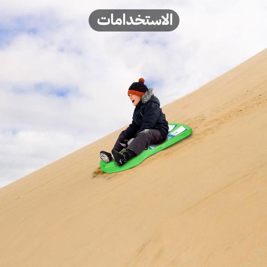 طفل يتزلج على كثبان رملية باستخدام زلاجة صحراوية خضراء بمقبض من