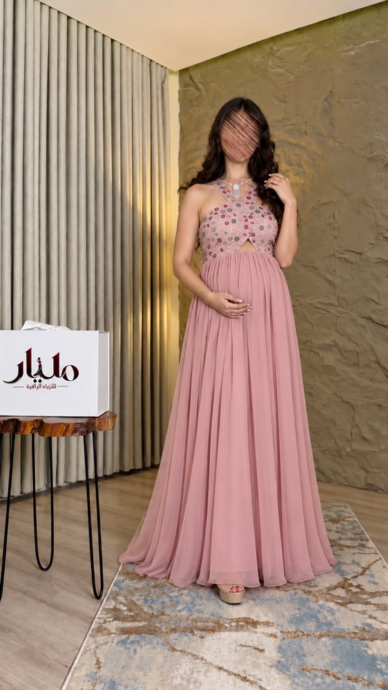فستان سهرة حوامل وردي مطرز من الأمام يوضح القصة المريحة والتنورة الطوي