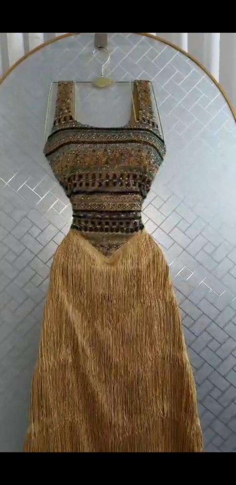فستان سهرة ذهبي فاخر بكورسيه مطرز وطبقات شراشيب عصرية
