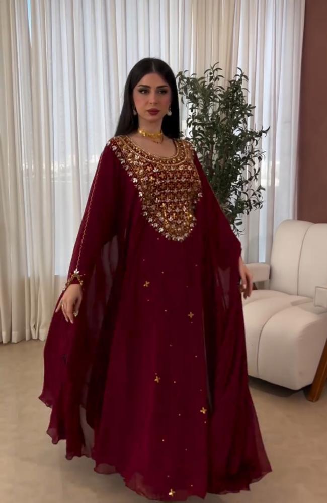 جلابية عنابية فاخرة بتصميم تقليدي واسع وأكمام واسعة مزينة بتطريزات يدوية ذهبية وفضية كثيفة على الصدر