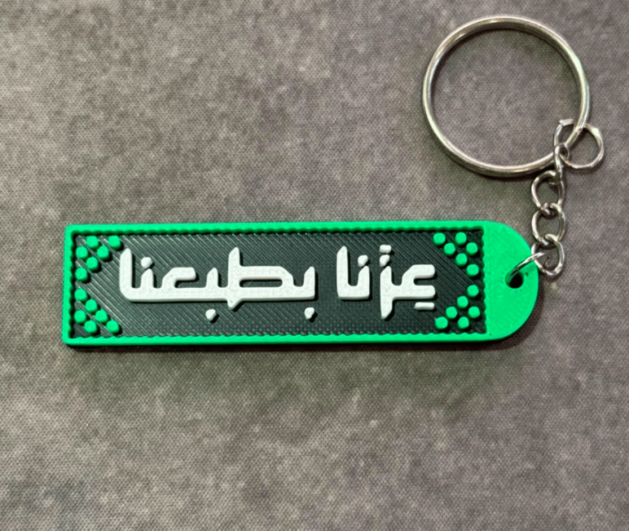 ميدالية مفاتيح "عِزّنا بطبعنا"