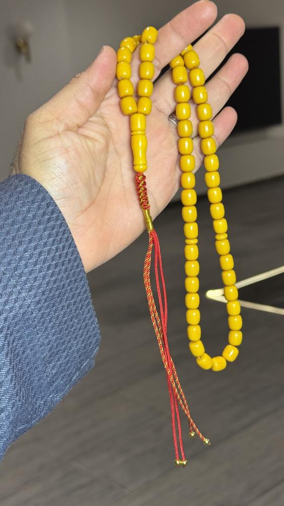 A Tasbih with a leather strap and a decorative pendant
