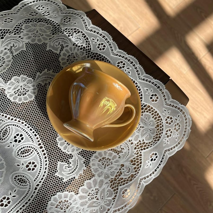 Bella Maison Clara porcelain coffee cup in mustard color features a glossy surface.