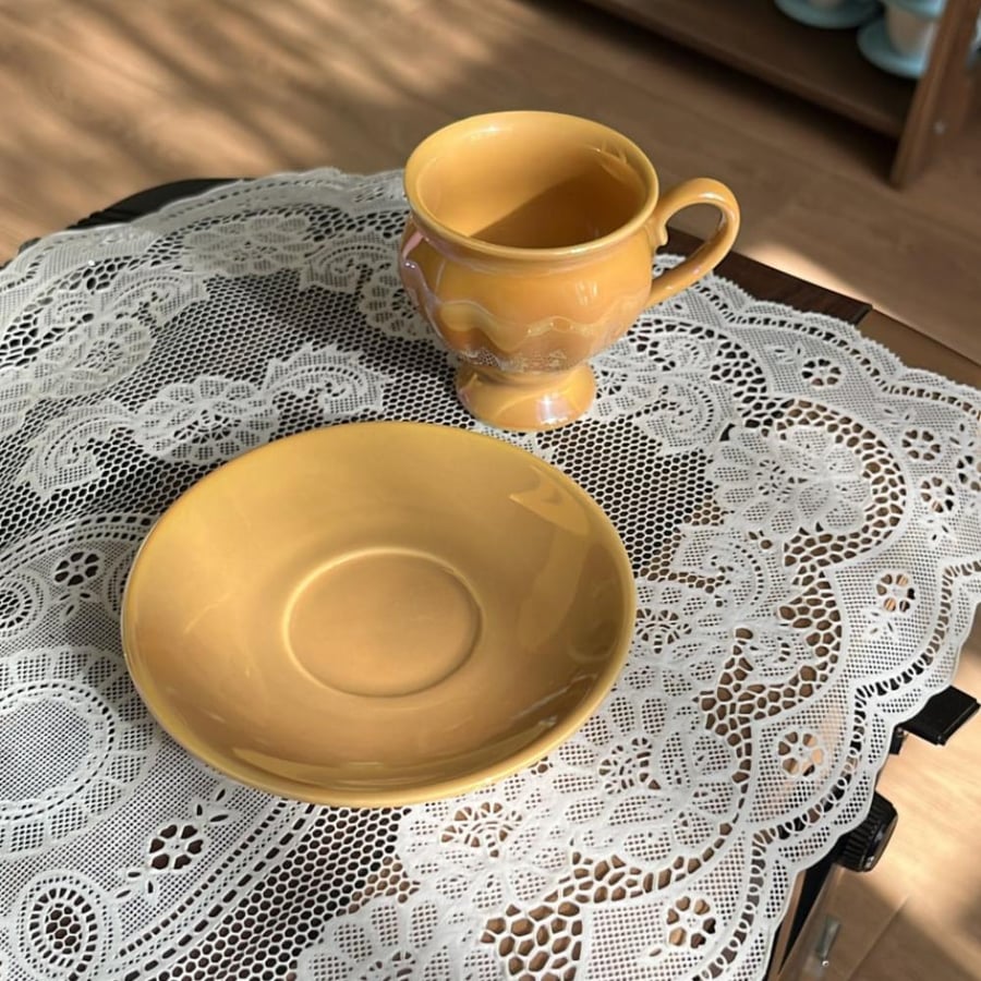 Bella Maison Clara porcelain coffee cup in mustard color features a glossy surface.