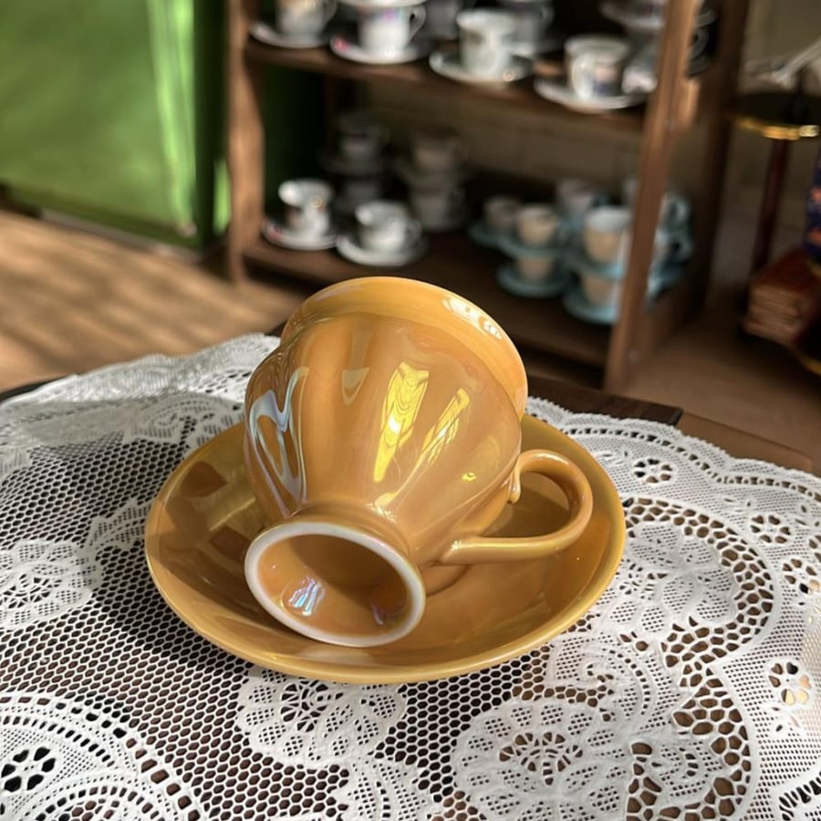 Bella Maison Clara porcelain coffee cup in mustard color features a glossy surface.