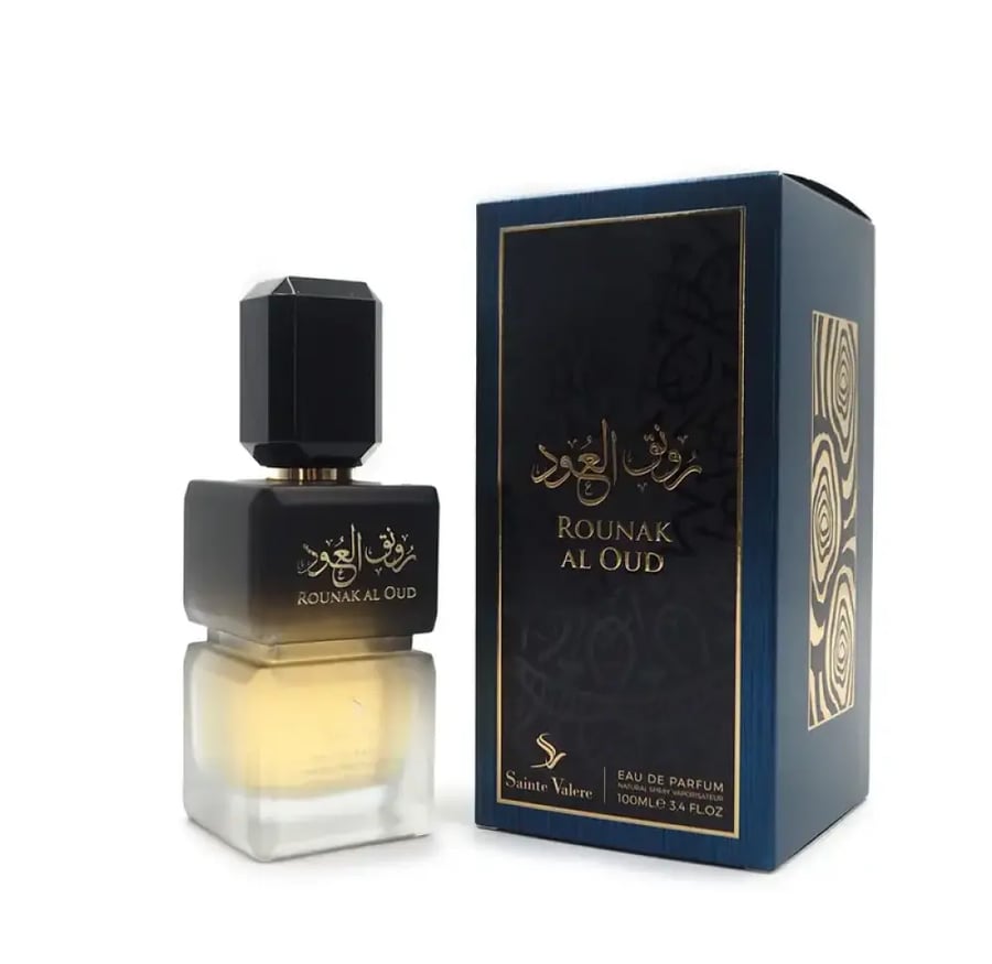 زجاجة عطر رونق العود موضوعة بجانب الغلاف الخارجي الفاخر
