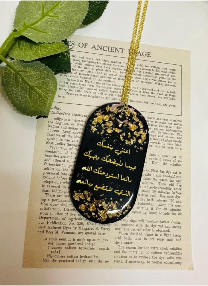 Face decoration pendant with one side phrase in black embroidered with gold leaf from luxurious resin