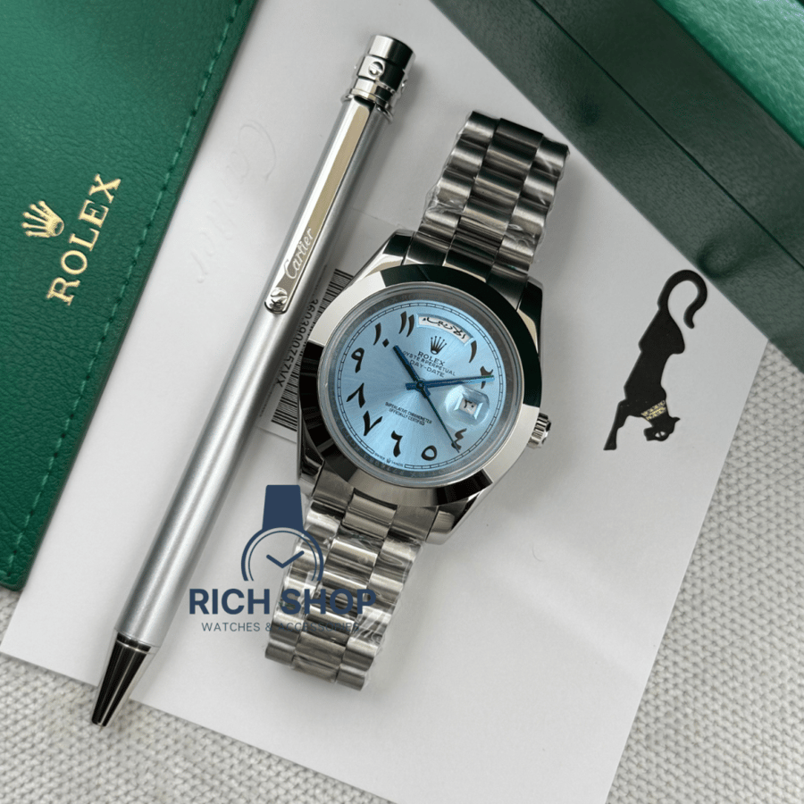 Sky blue Rolex watch set with a thin silver Cartier pen