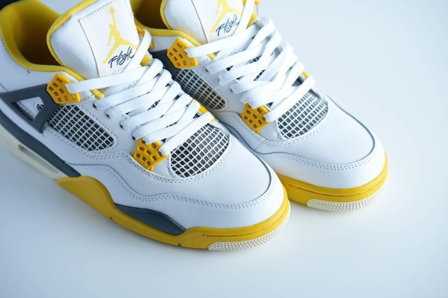 حذاء Jordan 4 Retro أبيض وأصفر بتفاصيل شبكية ولمسة عصرية
