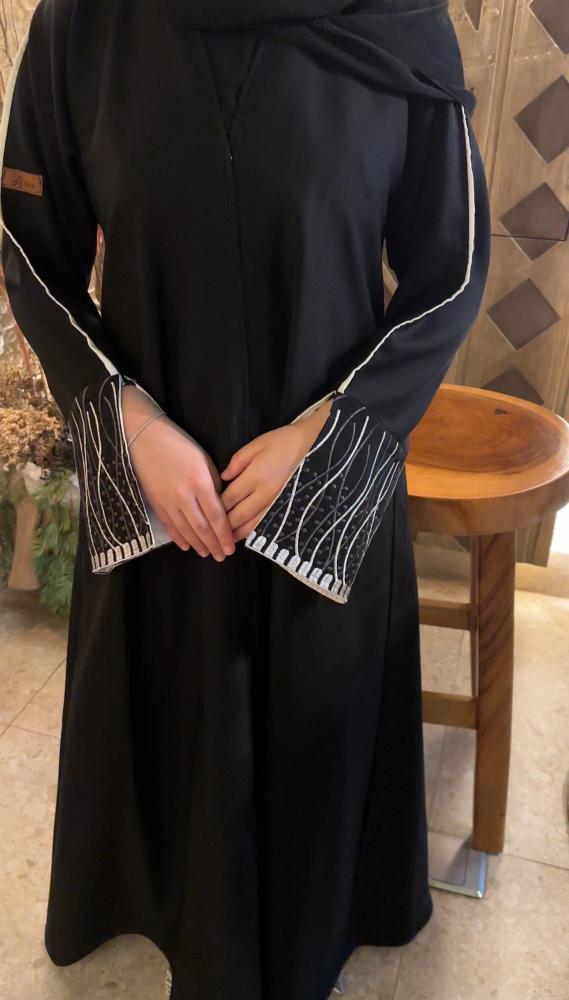 عباءة مطرزة بخطوط ملونة تجمع بين الاناقه والعمليه