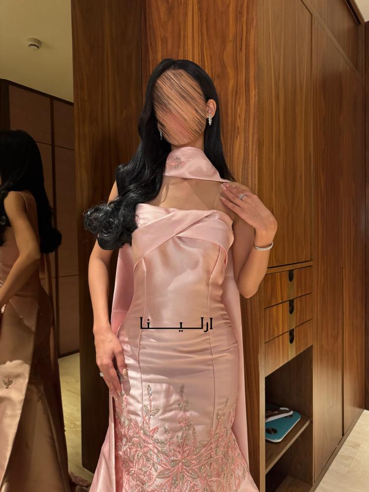 فستان بينك فاتح بقصة راقية مع ذيل منسدل يضفي حضورا أنيقا وإطلالة ملفتة