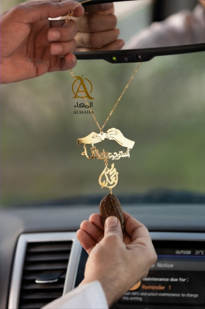 A pendant of a broken oud, held with both hands, holding the heart
