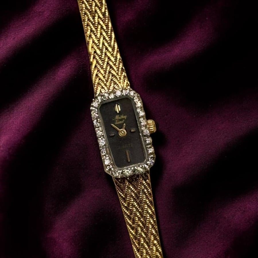 قطعة فاخرة ونادرة من Mathey Tissot السويسرية ، بسوار انيق باللون الذهبي وميناء اسود و ومزين بحبات الالماس الطبيعي. من ثمانينات القرن الماضي. الساعه تعمل بشكل ممتاز. مقاس 8 انش وقابله للتصغير. ليست مجرد ساعة... بل مجوهرات تحكي وقتك بأناقة.