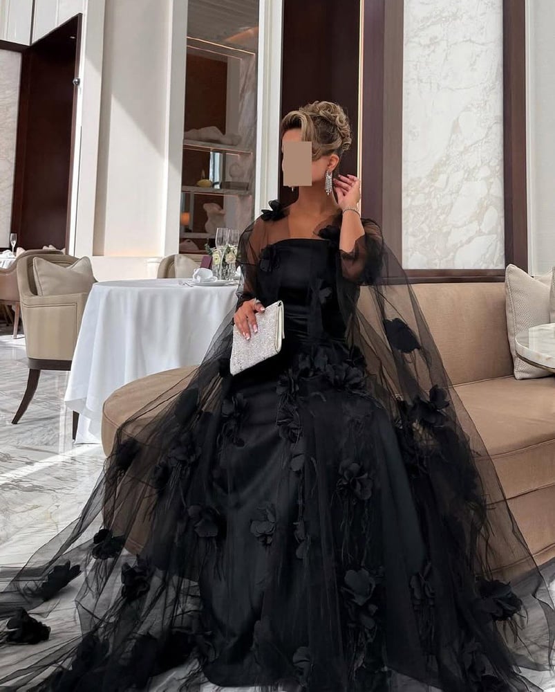 فستان سهرة طويل باللون الأسود، يتميز بتصميم أنيق وفخم.