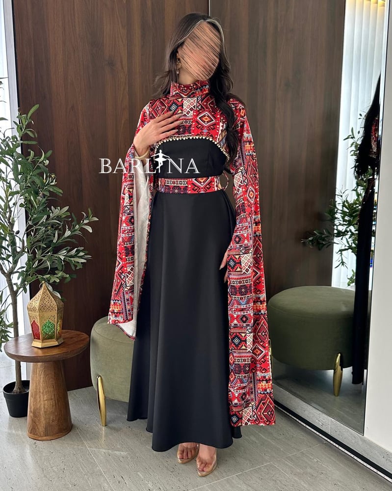 فستان أسود طويل مع عباءة/كاب علوية مزينة بنقوش تراثية ملونة