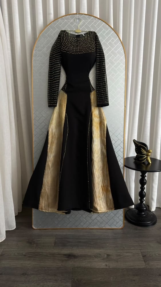 فستان سهرة طويل وأنيق باللونين الأسود والذهبي