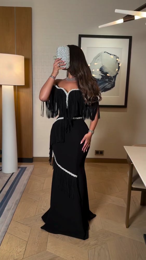 فستان سهرة طويل بلون أسود ومزين بالهدب (الشراشيب) والكرستال