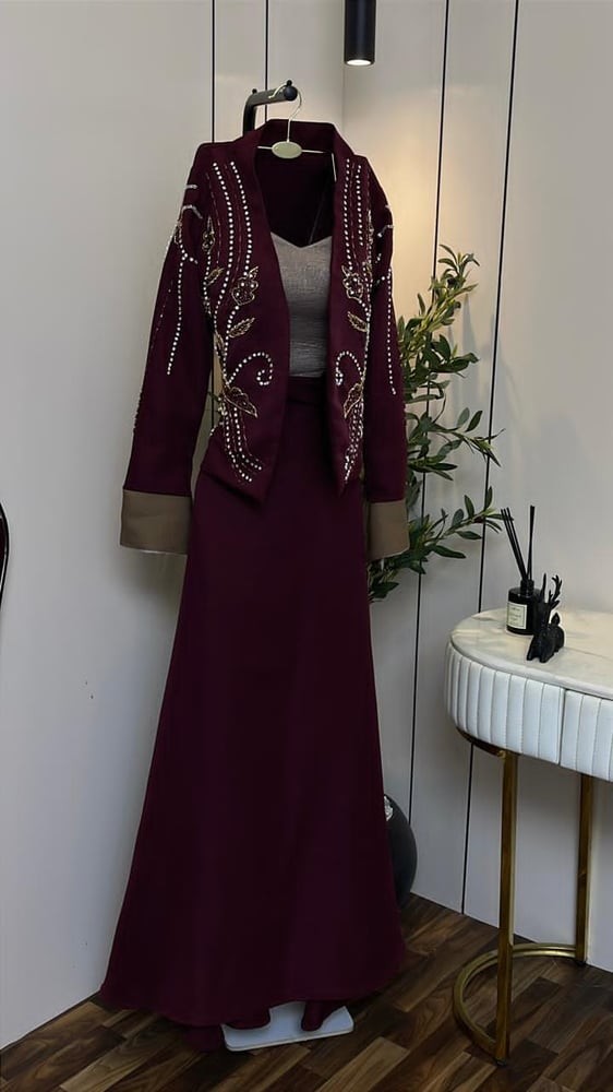 فستان سهرة راقي يتميز بتصميم أنيق يتضمن جاكيت مطرز يدويًا