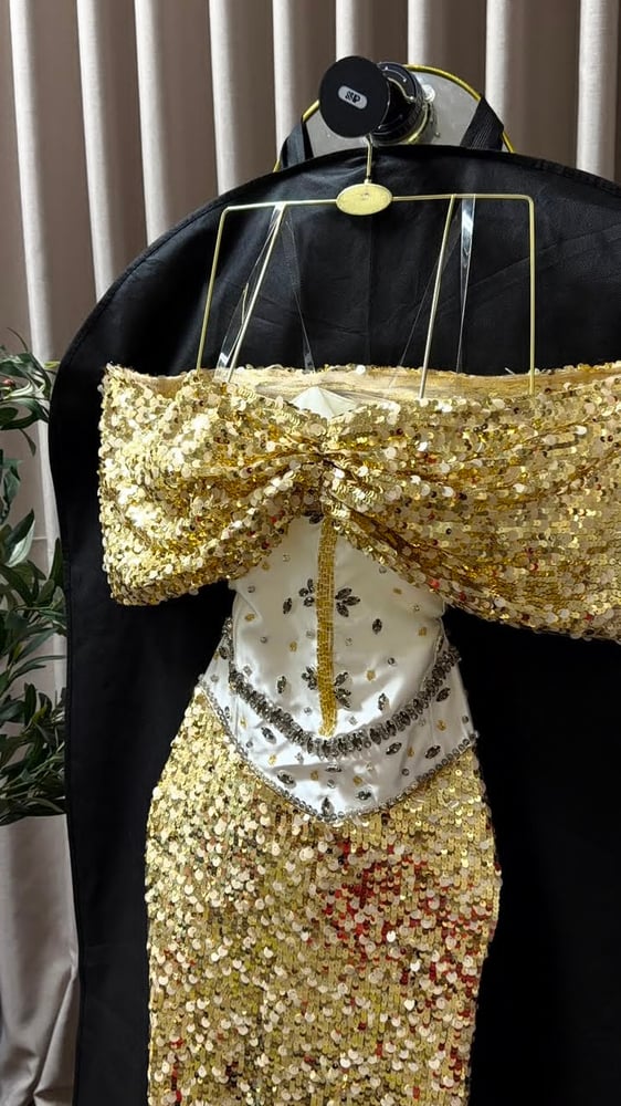 فستان سهرة فاخرًا بلون ذهبي لامع ومطرز بالكامل بالترتر