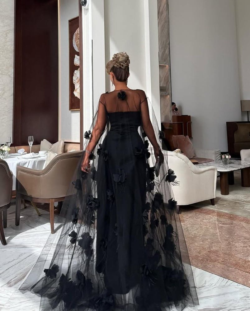 فستان سهرة طويل باللون الأسود، يتميز بتصميم أنيق وفخم.