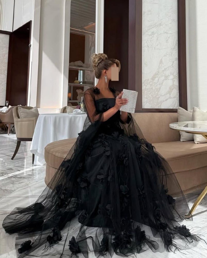 فستان سهرة طويل باللون الأسود، يتميز بتصميم أنيق وفخم.