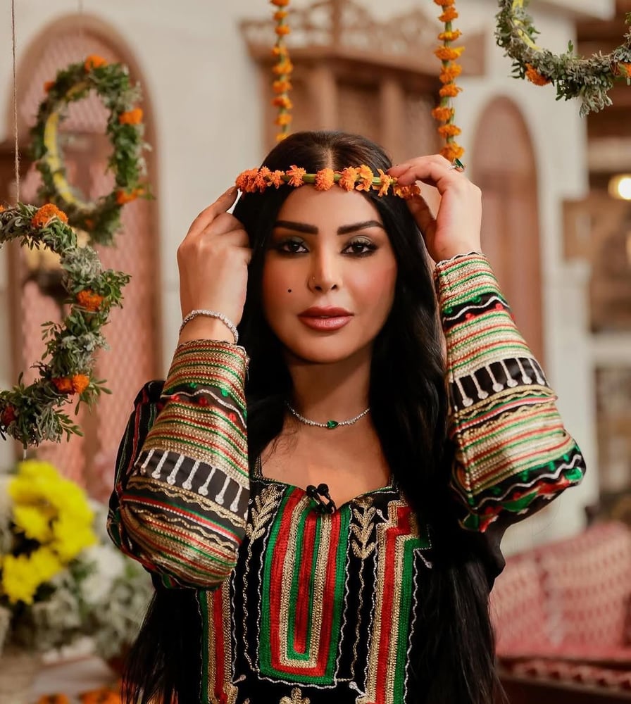 فستان أسود طويل مزين بتطريزات عسيرية ملونة