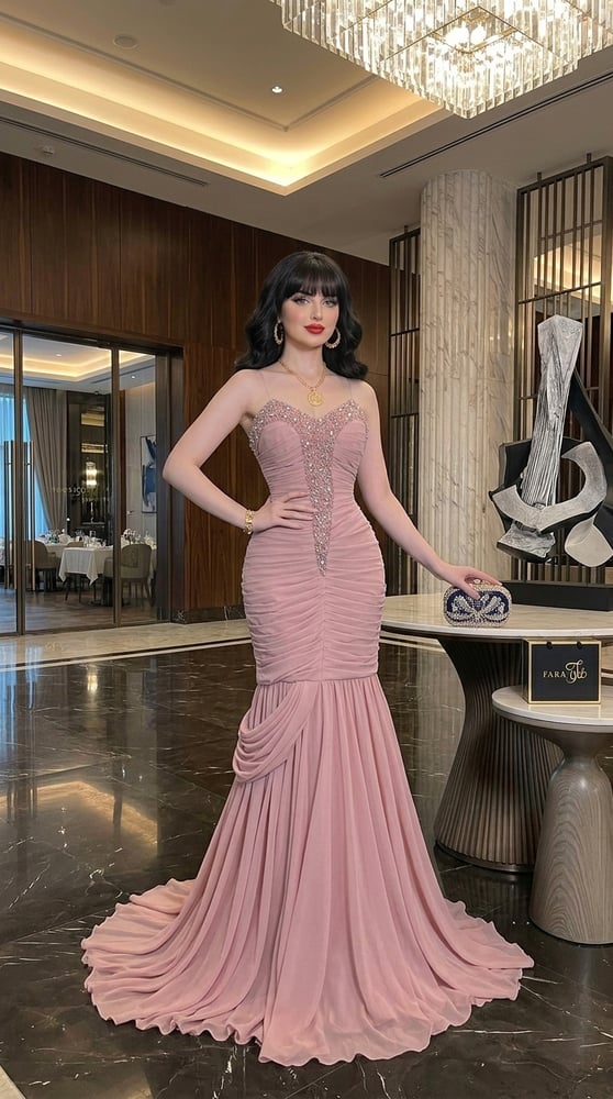 فستان سهرة طويل باللون الوردي ومزين بتطريز يدوي دقيق