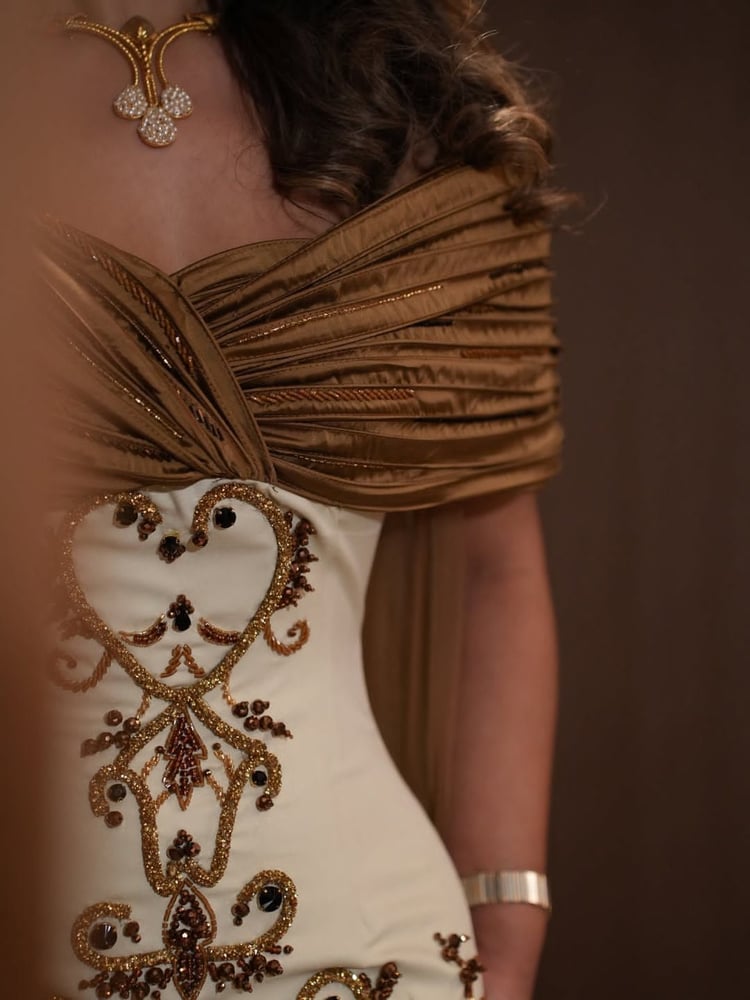 فستان سهرة فخم يجمع بين اللونين السكري والذهبي،
