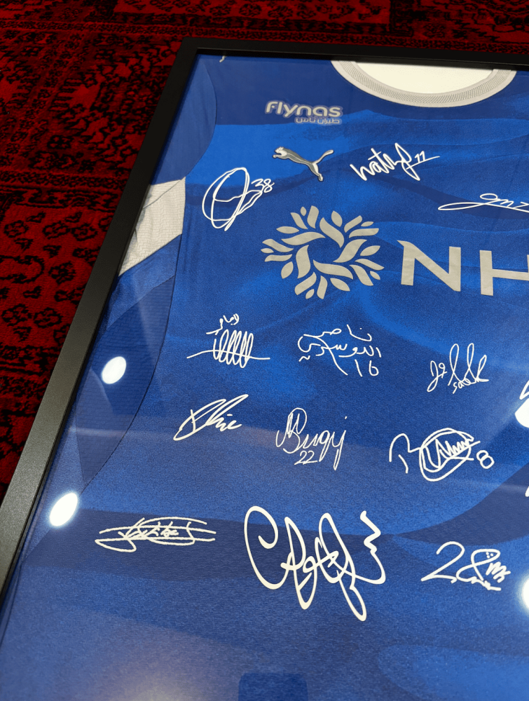 برواز تيشيرت الهلال الأساسي 2026/27 مُوقع من اللاعبين