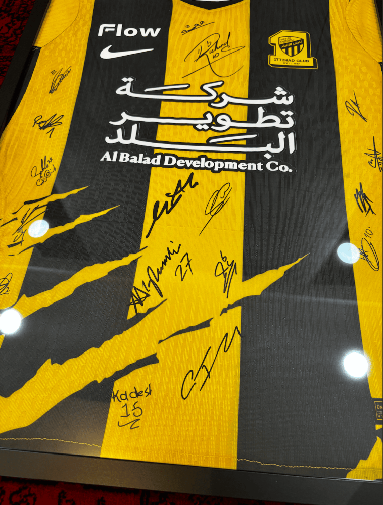 برواز تيشيرت الاتحاد الأساسي 2026/27 مُوقع من اللاعبين