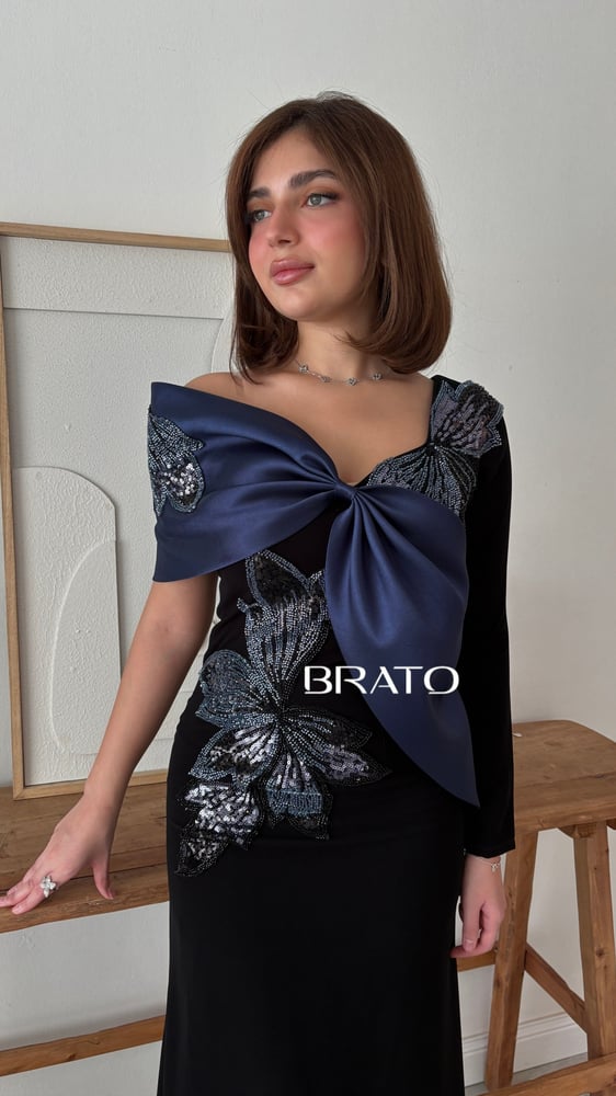 فستان سهرة أسود طويل بفيونكة كحلية وتطريز فراشات لامع