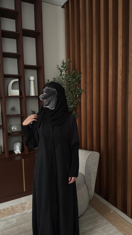 عبايه مصنوعة بقماش الحرير المغسول باللون الاسود مزينه باكمام لماع.