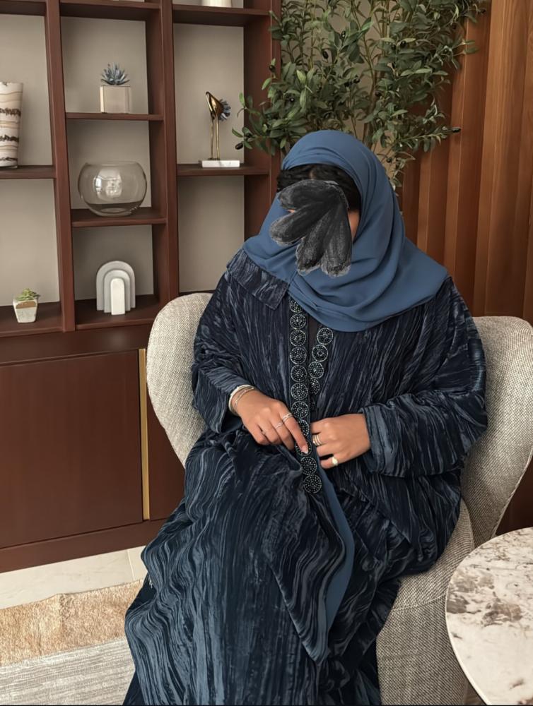 عباية مصنوعة من قماش المخمل بلون أزرق مزينه بكلفه دائرية .
