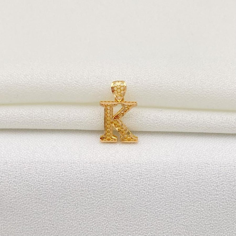 His pendant is the letter K in 21-karat gold.