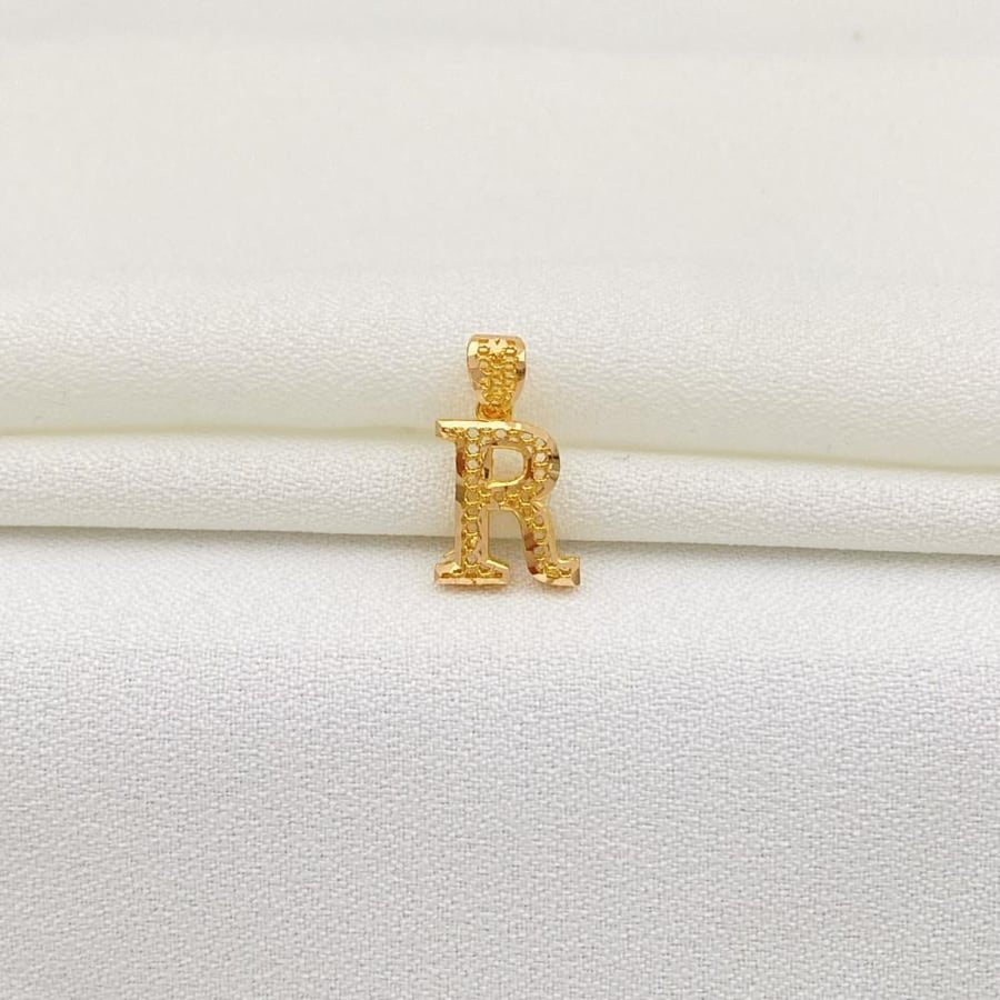 His pendant is the letter R in 21-karat gold.