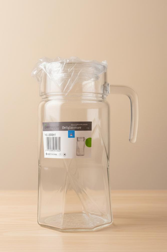 Transparent glass pitcher with lid in a modern design for serving drinks