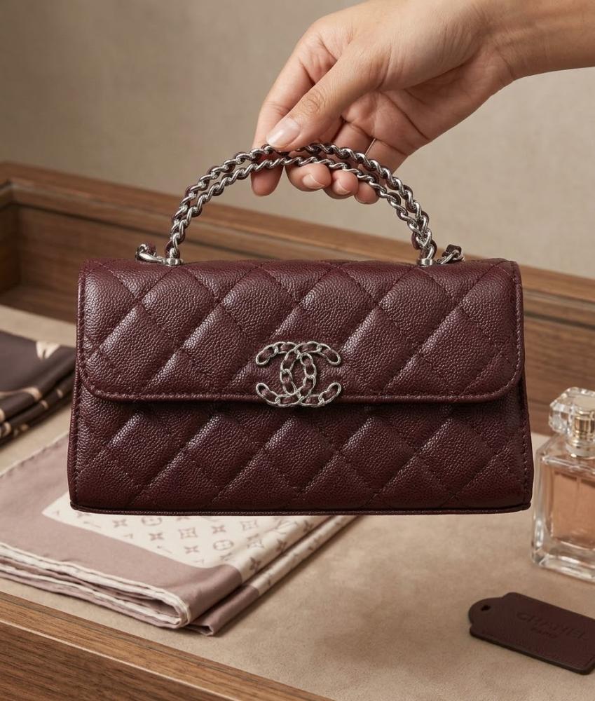 حقيبة يد نسائية من ماركة شانيل CHANEL صغيرة مبطنة باللون الأبيض مع سلسلة من الذهب.
