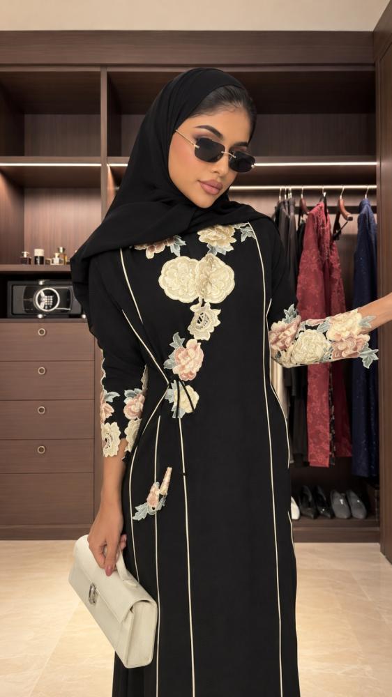 عباية سوداء مزينة بتطريز ورد ملون وفاتح على الصدر والأكمام