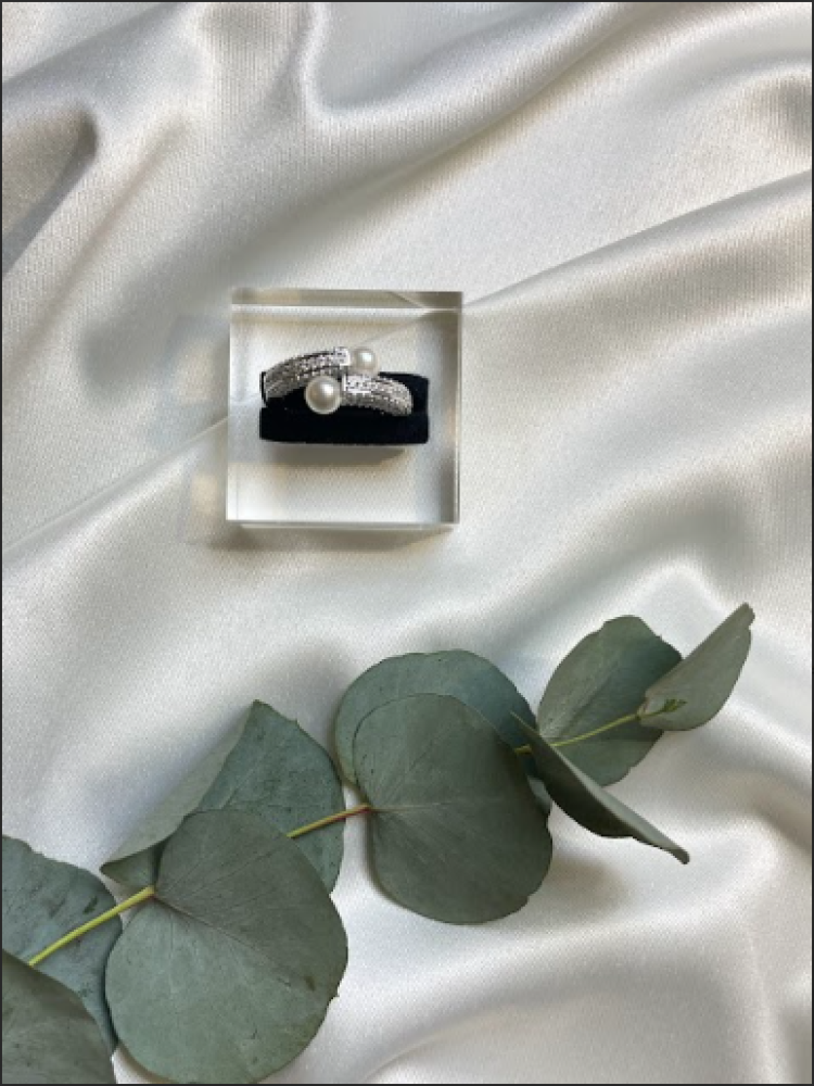 A ring set with zircon and decorated with pearls