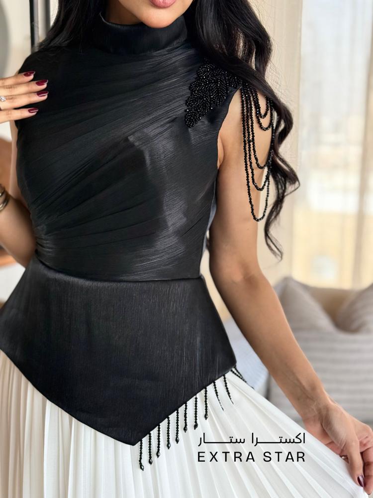 فستان أسود وأبيض بتفاصيل علوية أنيقة وتنورة بليسيه ناعمة