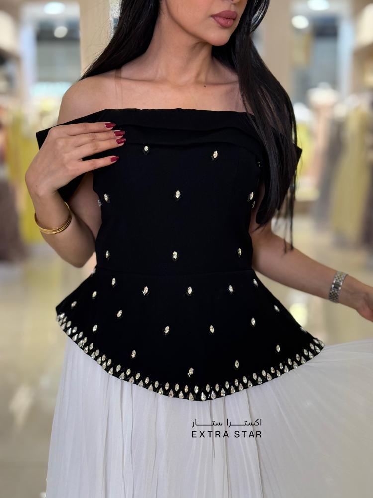 فستان أسود وأبيض أوف شولدر بجزء علوي مرّصع وتنورة بليسيه ناعمة