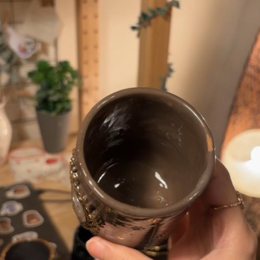 فراشة ذهبية بكوب داكن