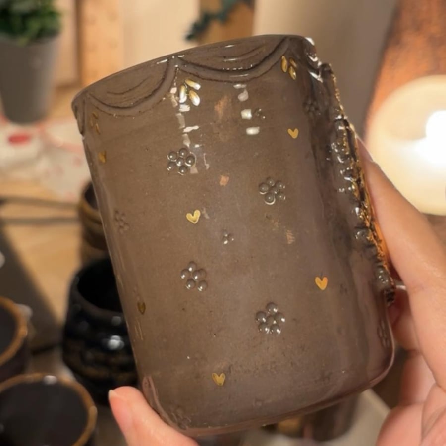 فراشة ذهبية بكوب داكن