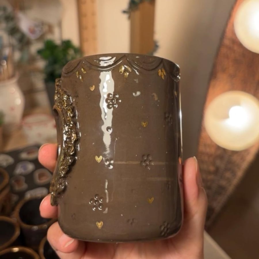 فراشة ذهبية بكوب داكن
