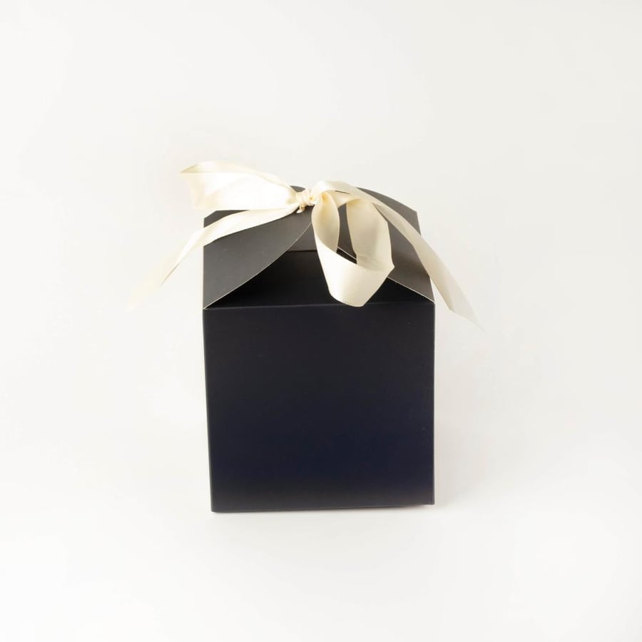علب كرتون كحلي مزخرفة بنقشات راقية وشريطة لتوزيعات عيد الفطر والأضحى