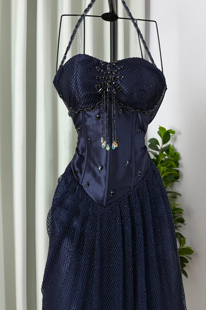 تفاصيل التطريز اليدوي وفصوص الزركون على فستان سهرة كحلي فخم