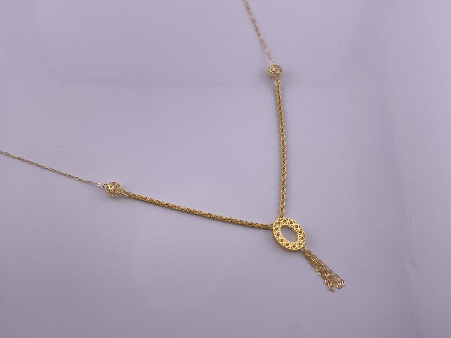 A gold necklace with an elegant and delicate design reflecting the beauty of details 21-karat gold