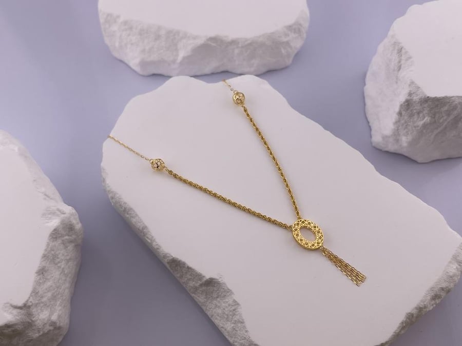 A gold necklace with an elegant and delicate design reflecting the beauty of details 21-karat gold